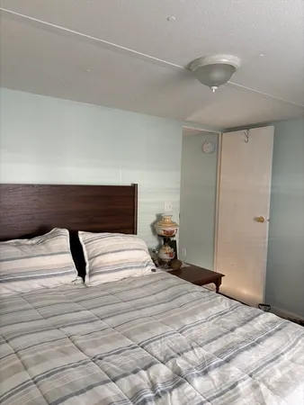 a bedroom with a bed and a lamp on the dresser