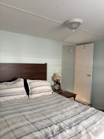 a bedroom with a bed and a lamp on the dresser