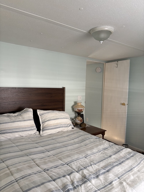 557 Southwest Cutoff, Unit 17 Worcester, MA 01607 - Photo 9 of 19 a bedroom with a bed and a lamp on the dresser