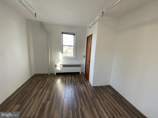 a view of a room with wooden floors and window