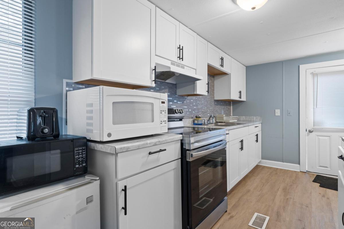 158 Thomas Field Road Southeast Milledgeville, GA 31061 - Photo 10 of 28 a kitchen with stainless steel appliances granite countertop a stove a sink and a refrigerator