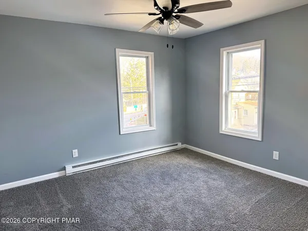 a hallway with a chandelier and a dining table