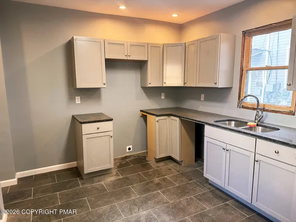 a kitchen with a sink a stove and cabinets