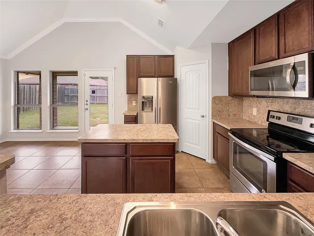 a kitchen with stainless steel appliances granite countertop a sink and a stove top oven