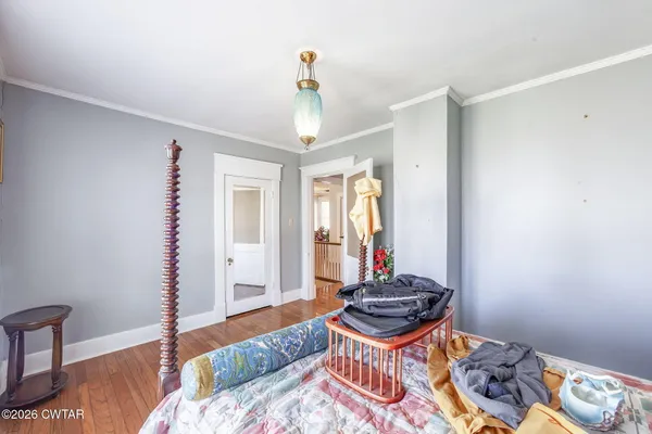 a bedroom with a bed a dresser and next to a window