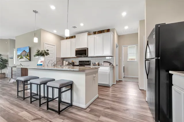 a kitchen with white cabinets and stainless steel appliances