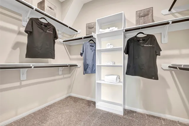a view of walk in closet with clothes and shoes