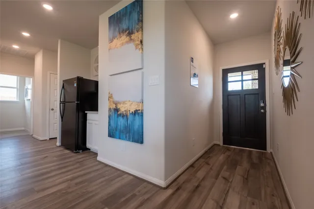 a view of a hallway with wooden floor and staircase