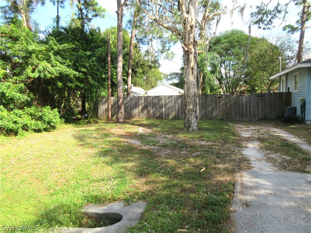 18415 Miller Road Fort Myers, FL 33967 - Photo 20 of 21 a view of a backyard with large trees and wooden fence