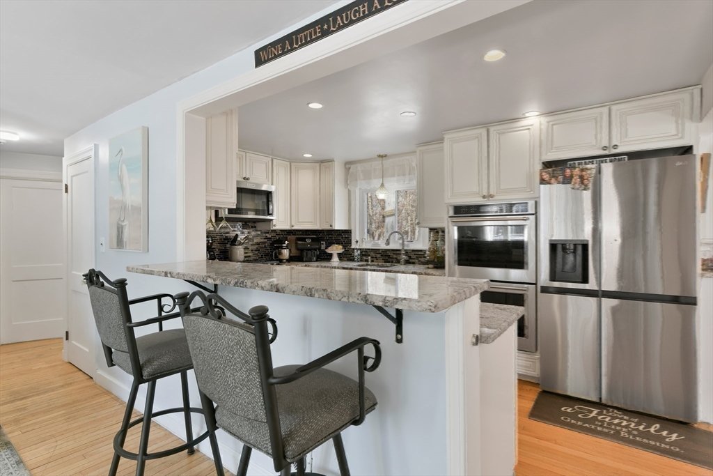 22 Stratford Road Natick, MA 01760 - Photo 13 of 41 a kitchen with granite countertop a refrigerator stove microwave and cabinets