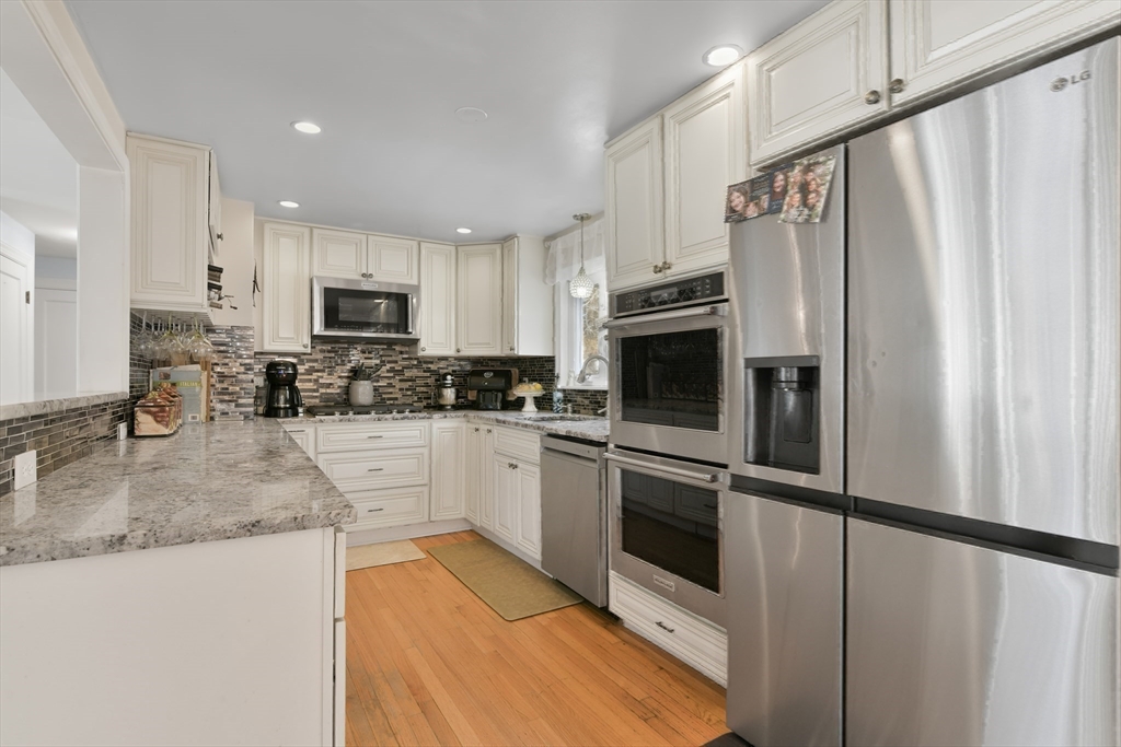 22 Stratford Road Natick, MA 01760 - Photo 15 of 41 a kitchen with granite countertop a refrigerator stove and microwave
