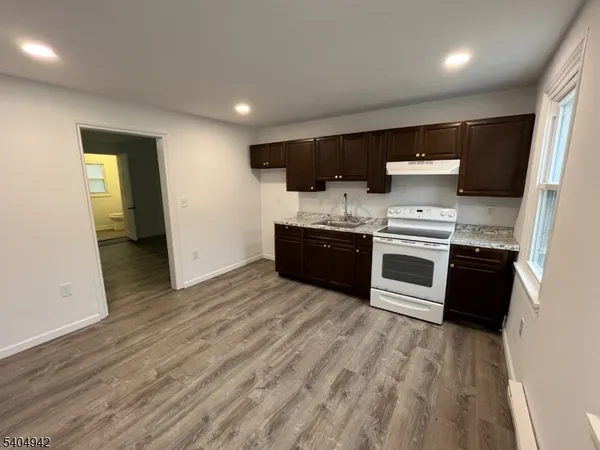 a large kitchen with stainless steel appliances granite countertop a stove and a sink