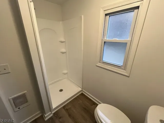 a bathroom with a toilet and a shower