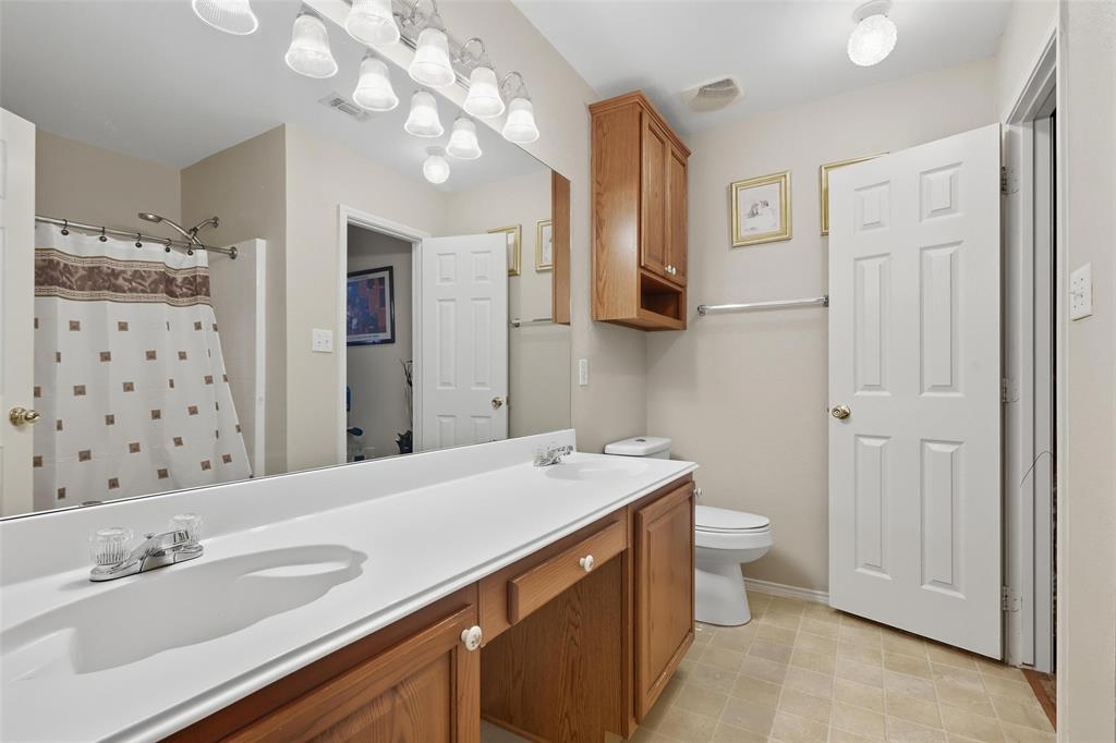 5200 Mountain Spring Trail Fort Worth, TX 76123 - Photo 7 of 23 a bathroom with a sink a toilet a large mirror and shower