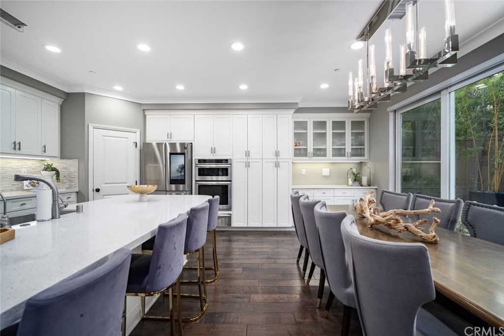 52 Umbria Irvine, CA 92618 - Photo 7 of 50 a kitchen with stainless steel appliances kitchen island granite countertop a dining table chairs and refrigerator