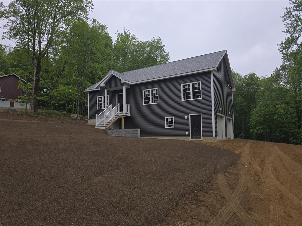 1242 Bemis Road Warren, MA 01083 - Photo 3 of 25 a front view of a house with a yard and garage