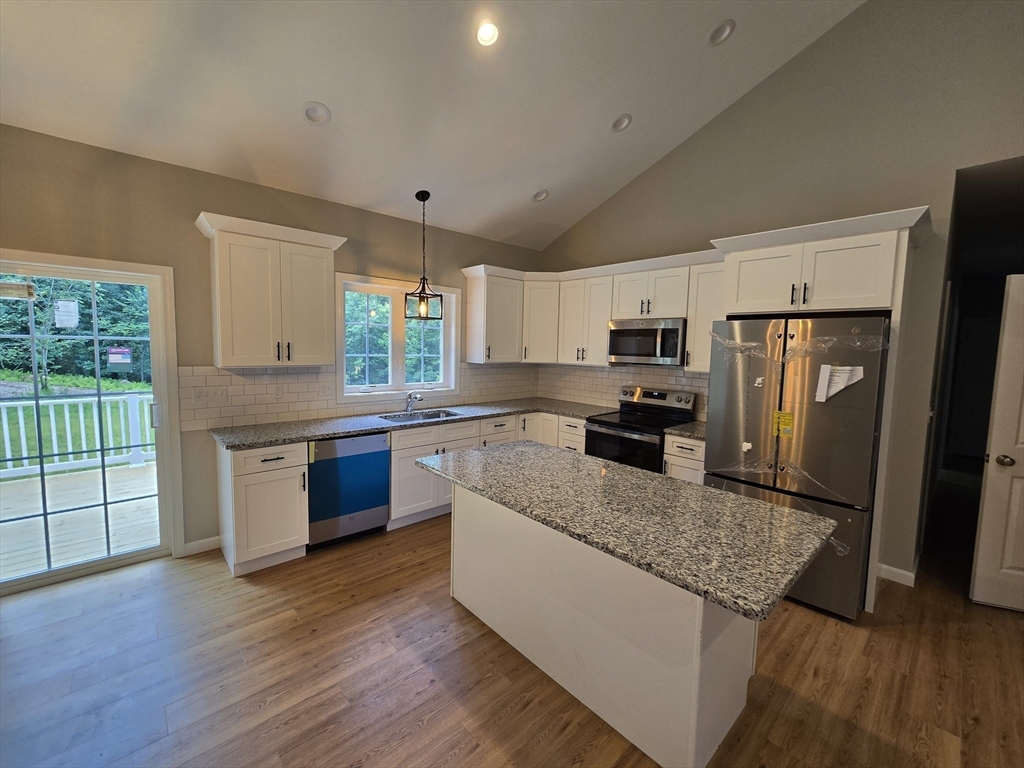 1242 Bemis Road Warren, MA 01083 - Photo 8 of 25 a kitchen with granite countertop wooden floors stainless steel appliances and a window