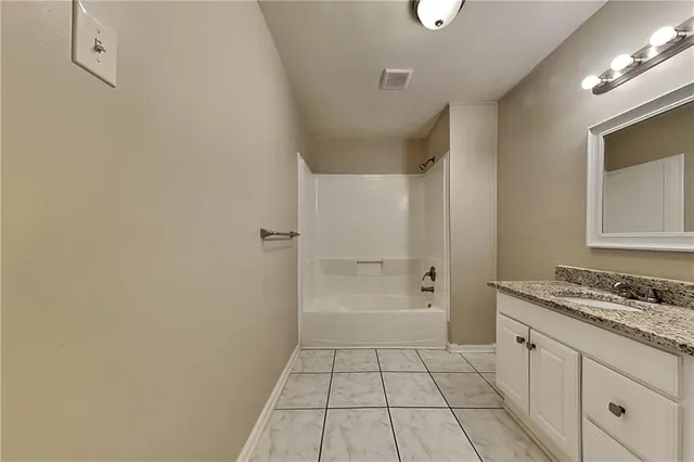 a bathroom with a granite countertop sink a toilet and a mirror