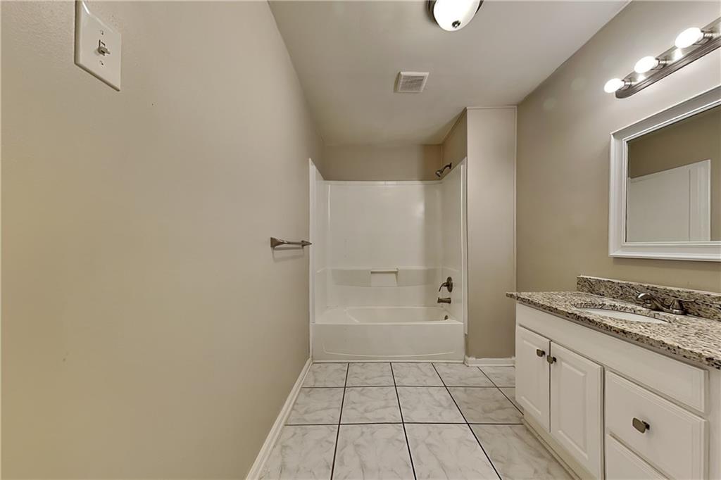 404 Rams Court Tucker, GA 30084 - Photo 17 of 21 a bathroom with a granite countertop sink a toilet and a mirror