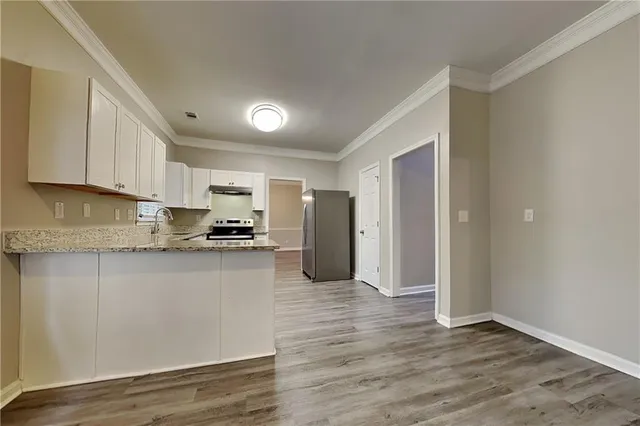 a kitchen with stainless steel appliances granite countertop a refrigerator and a stove top oven