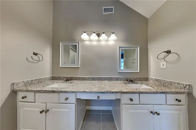 a bathroom with a granite countertop sink and a mirror