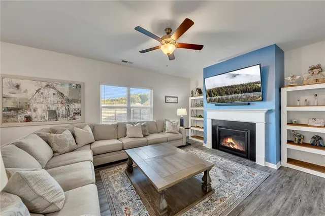 a living room with furniture a flat screen tv and a fireplace