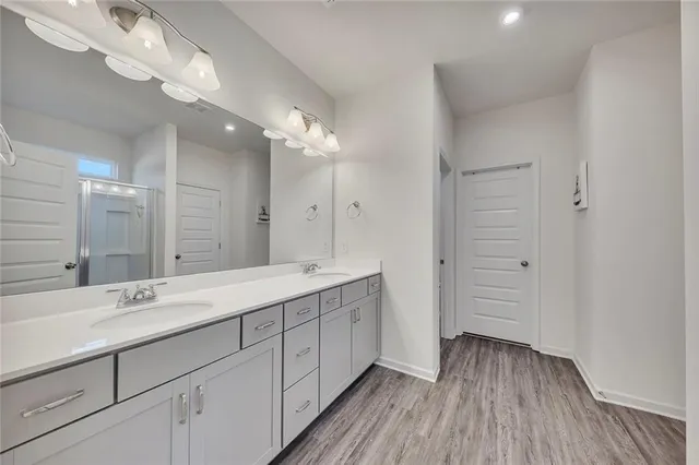 a spacious bathroom with a double vanity sink and mirror