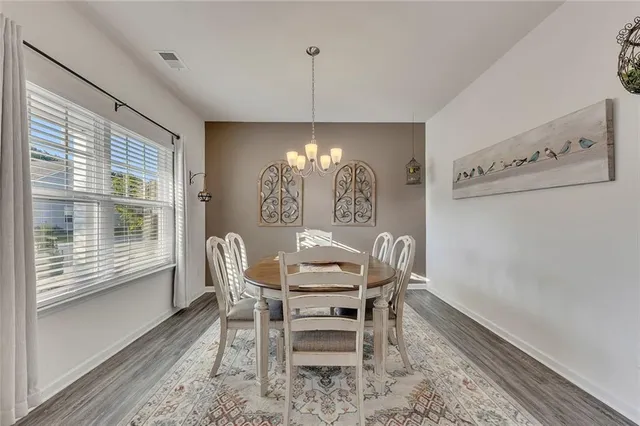 a dining room with furniture a chandelier and wooden floor