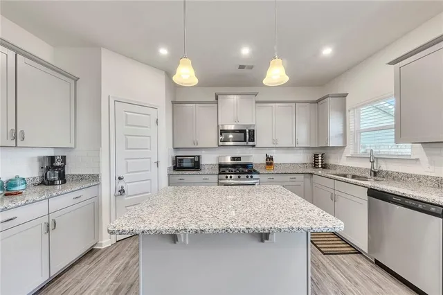 a kitchen with stainless steel appliances granite countertop a sink stove and refrigerator