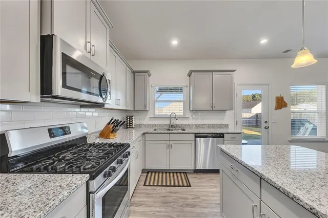 a large kitchen with granite countertop a stove sink and cabinets