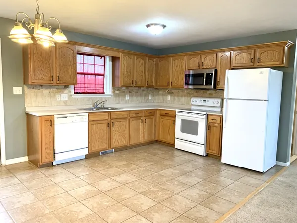 a kitchen with stainless steel appliances granite countertop a sink a stove a refrigerator and island