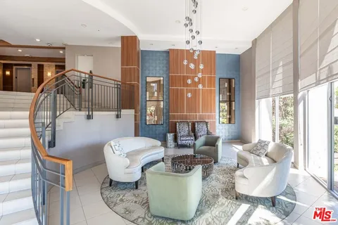a living room with furniture a fireplace and a chandelier