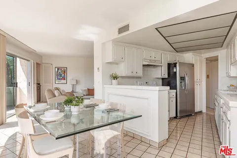 a kitchen with a sink a stove a refrigerator cabinets and dining table