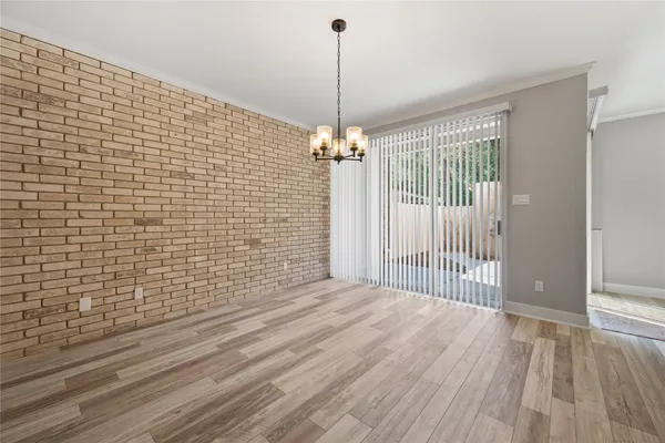 a view of a livingroom with wooden floor and a chandelier