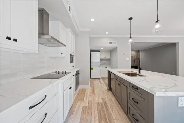 a large kitchen with a sink and stove