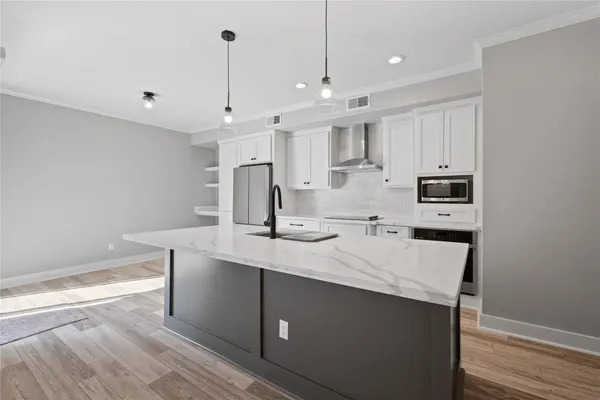 a kitchen with kitchen island a sink stainless steel appliances and cabinets