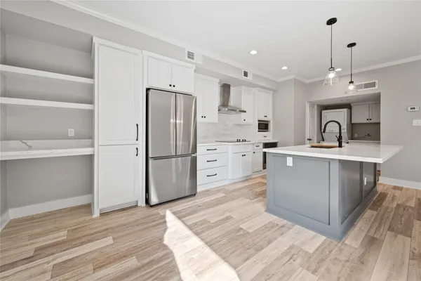 a kitchen with stainless steel appliances kitchen island a refrigerator sink and cabinets