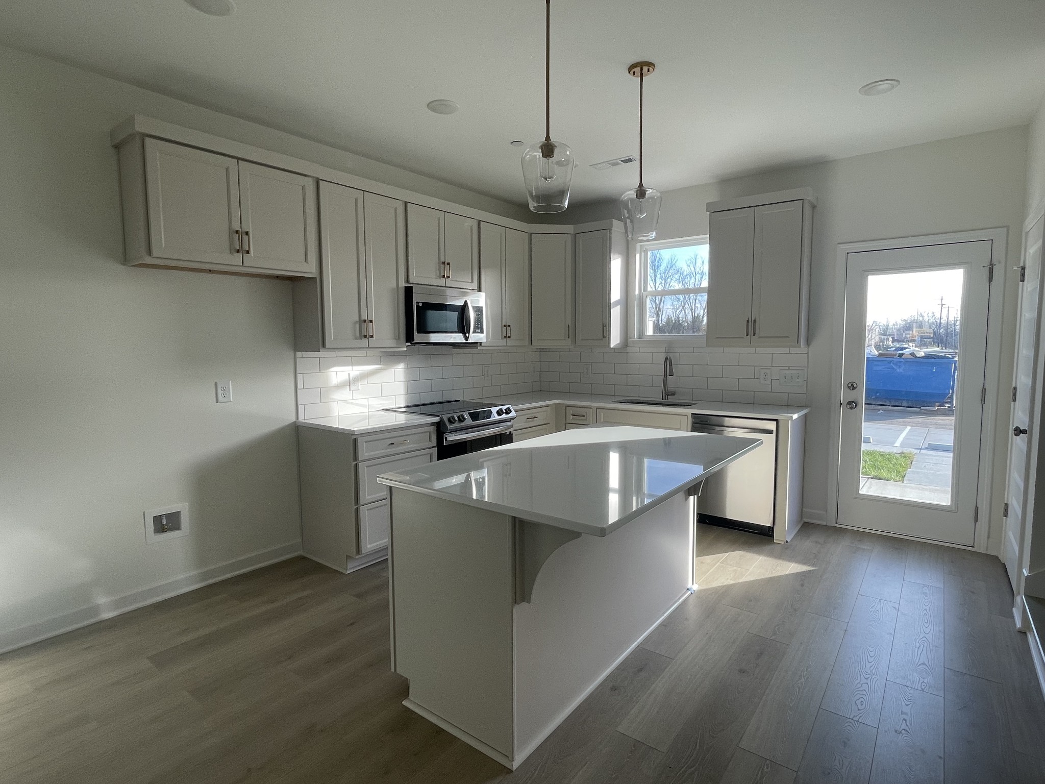 153 Bess Boulevard Spring Hill, TN 37174 - Photo 3 of 22 a kitchen with kitchen island granite countertop a sink cabinets and wooden floor