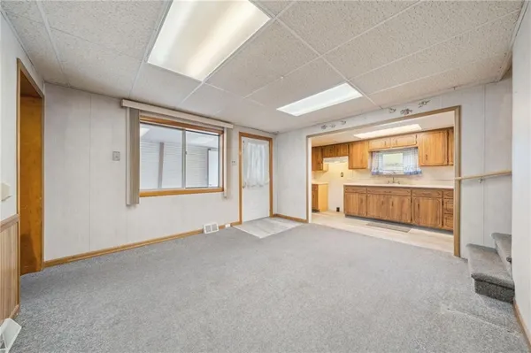 an empty room with cabinet and windows