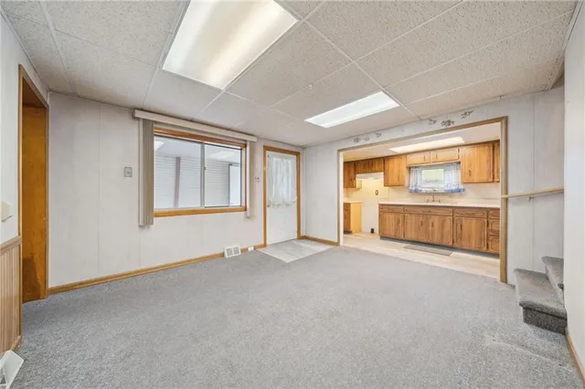 an empty room with cabinet and windows