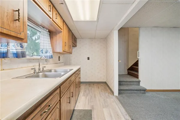 a kitchen with granite countertop a sink and dishwasher with wooden floor