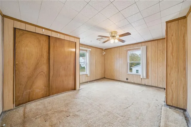 an empty room with windows and closet area