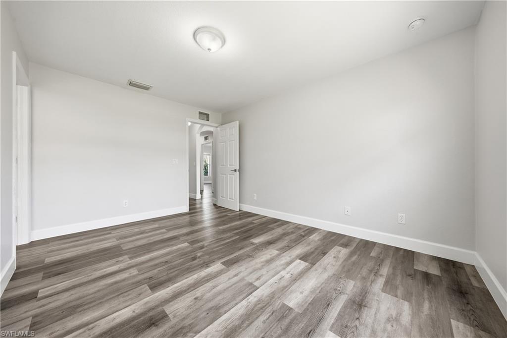 4621 25th Street Southwest Lehigh Acres, FL 33973 - Photo 24 of 41 a view of an empty room with wooden floor