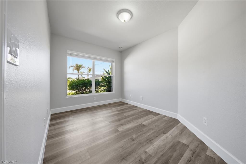 4621 25th Street Southwest Lehigh Acres, FL 33973 - Photo 25 of 41 an empty room with wooden floor and windows