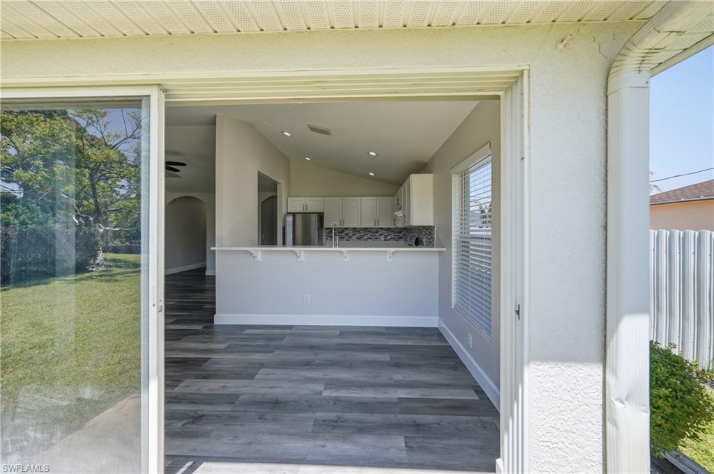 4621 25th Street Southwest Lehigh Acres, FL 33973 - Photo 28 of 41 a view of a hallway with wooden floor and a kitchen
