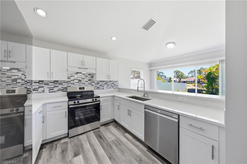 4621 25th Street Southwest Lehigh Acres, FL 33973 - Photo 3 of 41 a kitchen with white cabinets appliances and a window