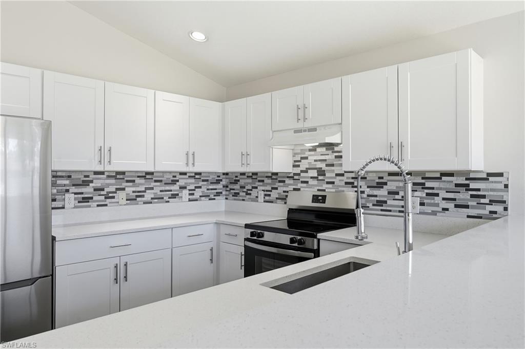 4621 25th Street Southwest Lehigh Acres, FL 33973 - Photo 4 of 41 a kitchen with white cabinets and appliances