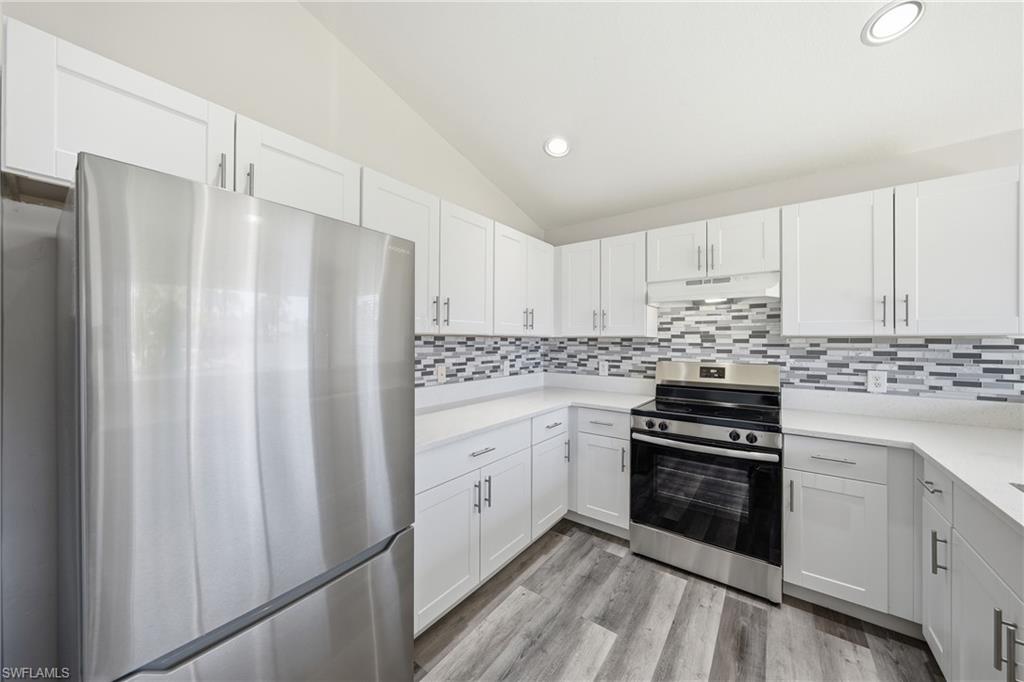 4621 25th Street Southwest Lehigh Acres, FL 33973 - Photo 5 of 41 a kitchen with stainless steel appliances a stove a sink and a refrigerator