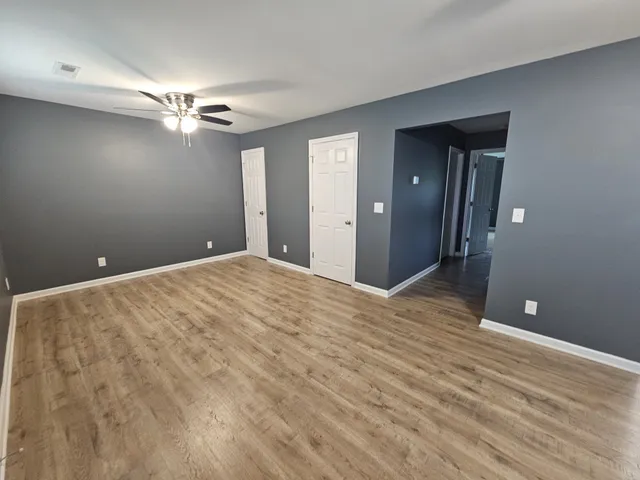 a view of empty room with wooden floor