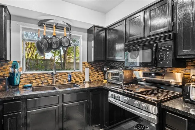 a kitchen with granite countertop a stove and a wooden cabinets
